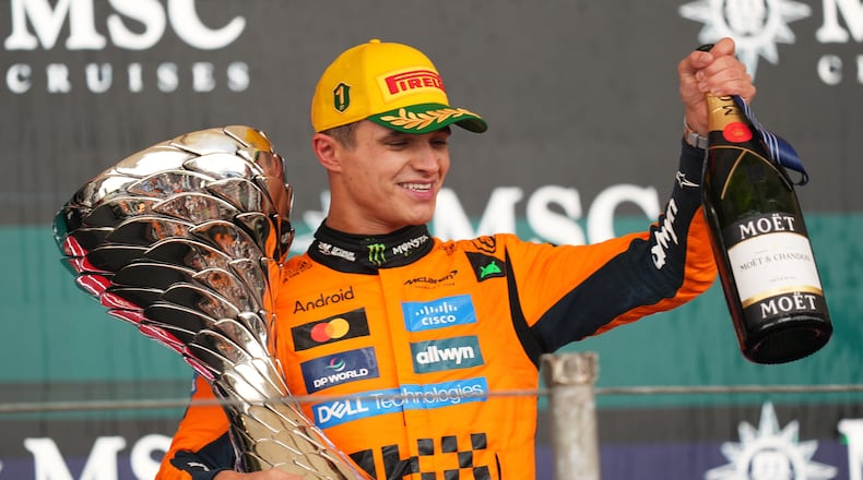 McLaren driver Lando Norris of Britain celebrates on the podium his first place in the Brazilian Formula One Grand Prix at the Interlagos race track in Sao Paulo, Sunday, Nov. 9, 2025. (AP Photo/Andre Penner)