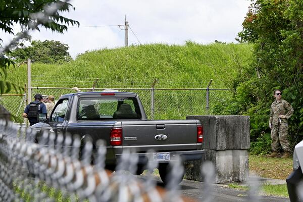U.S. military persons gather near the site of an explosion at a storage site for unexploded ordnances at a U.S. military base in the town of Yomitanson, Okinawa prefecture, southern Japan Monday, June 9, 2025. (Kyodo News via AP)