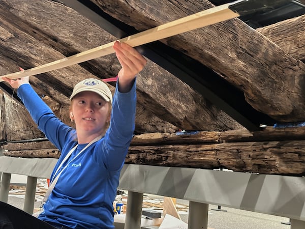 Research assistant Alyssa Carpenter works beneath a wooden Revolutionary War-era gunboat to prepare for the craft's partial reconstruction at the New York State Museum, Friday, May 30, 2025, in Albany, New York. (AP Photo/Michael Hill)