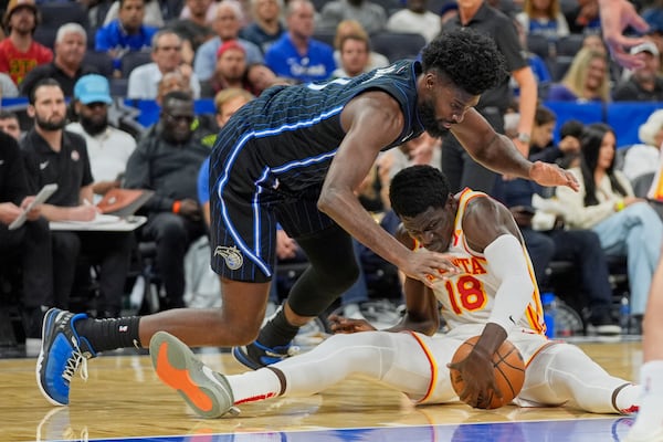 Atlanta Hawks forward Mouhamed Gueye (18) and Orlando Magic forward Jonathan Isaac, left, battle for a loose ball during the second half of an NBA basketball game, Tuesday, April 8, 2025, in Orlando, Fla. (AP Photo/John Raoux)
