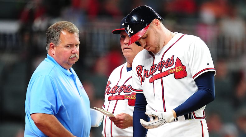ATLANTA, GA - MAY 17: Freddie Freeman #5 of the Atlanta Braves is removed by Manager Brian Snitker #43 as trainer Jim Lovell watches after being hit by a fifth inning pitch against the Toronto Blue Jays at SunTrust Park on May 17, 2017 in Atlanta, Georgia. (Photo by Scott Cunningham/Getty Images)