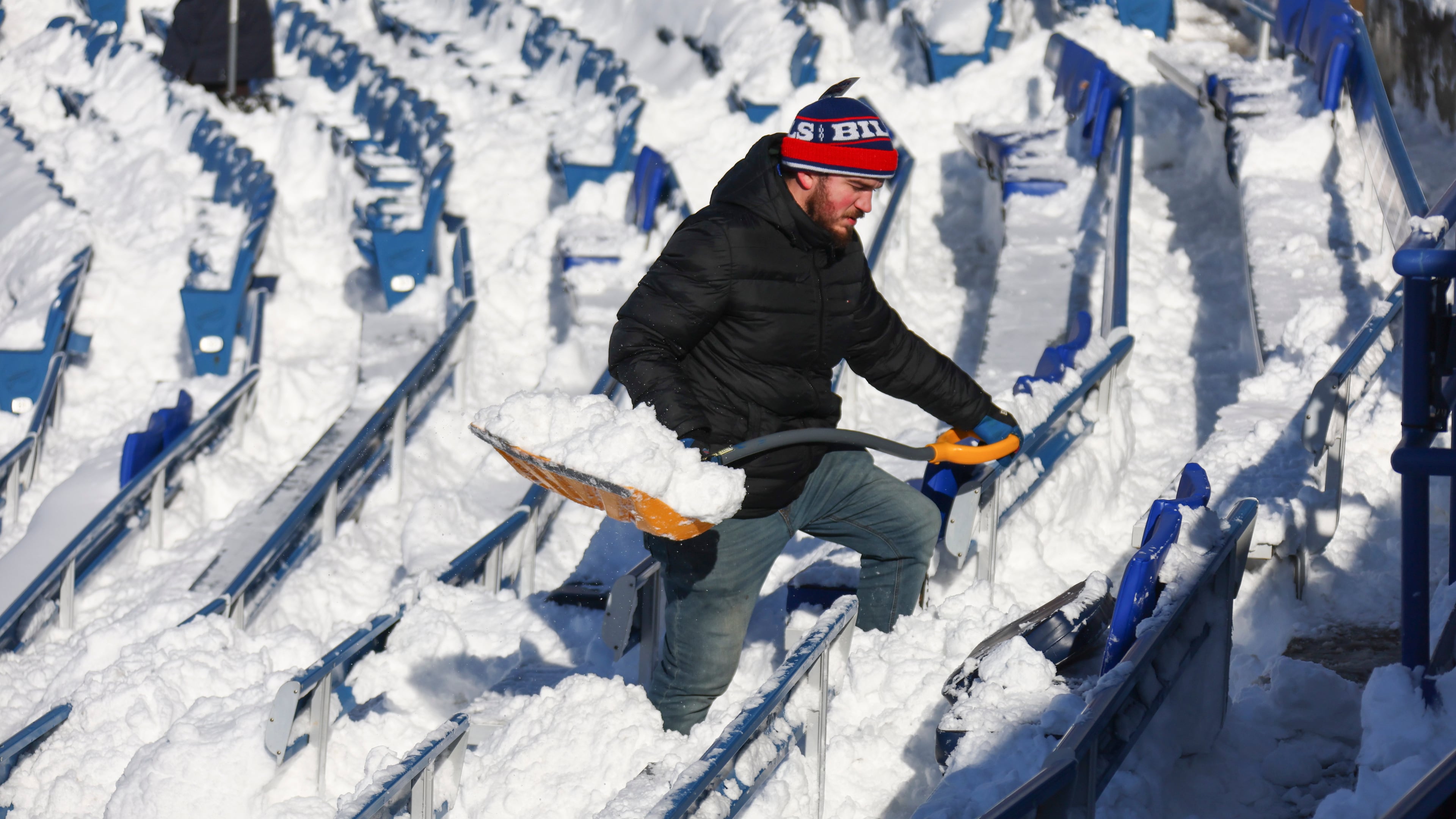 FILE - A stadium worker clears snow from seats before an NFL wild-card playoff football game between the Buffalo Bills and the Pittsburgh Steelers, Jan. 15, 2024, in Buffalo, N.Y. (AP Photo/Jeffrey T. Barnes, File)