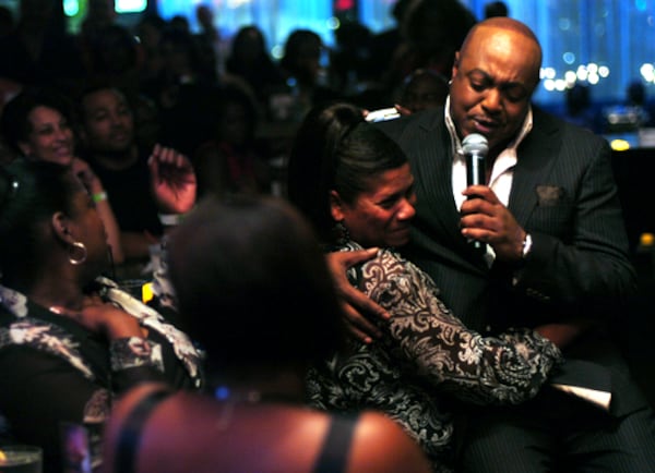 Peabo Bryson borrows Cynthia Bateman's lap and gets a hug during his performance at the Blue Room.