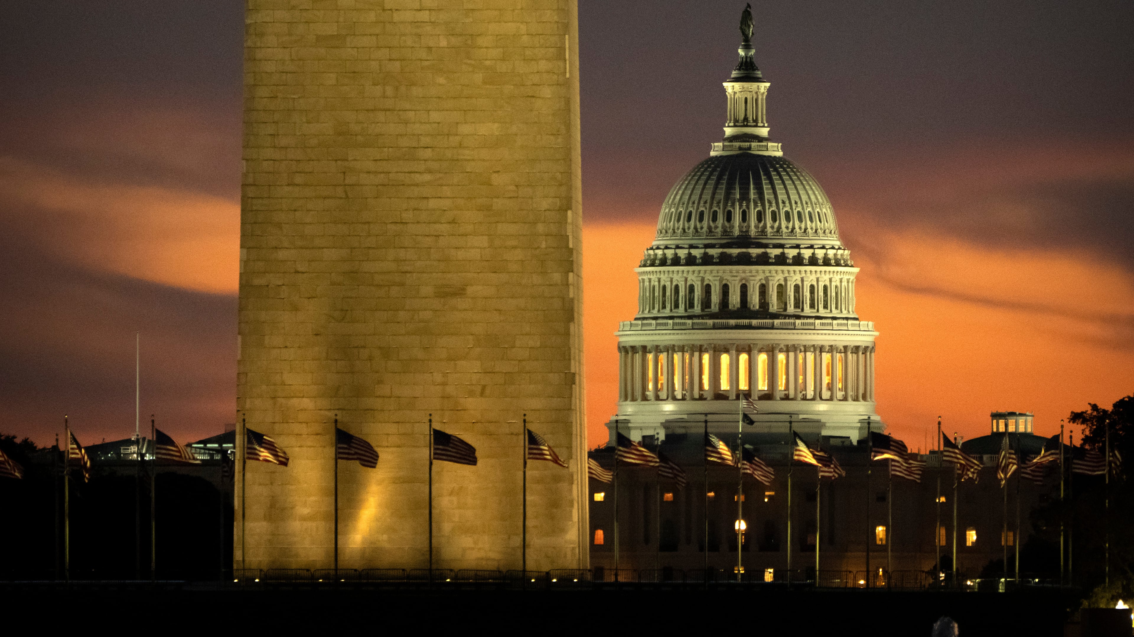 The base of the Washington Monument and the dome of the U.S. Capitol are seen at dawn on Wednesday, Oct. 1, 2025, in Washington. (AP Photo/Mark Schiefelbein)