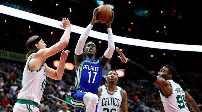 Atlanta Hawks guard Dennis Schroder (17) drives to the basket to shoot as Boston Celtics center Kelly Olynyk (41) and forward Jae Crowder (99) defend in the second half of an NBA basketball game on Thursday, April 6, 2017, in Atlanta. The Hawks won the game 123-116. (AP Photo/Todd Kirkland)