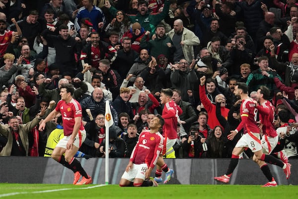 Manchester United's Harry Maguire, left, celebrates with team mates after his side's fifth goal during the Europa League quarter final second leg soccer match between Manchester United and Olympique Lyon in Manchester, Britain, Thursday, April 17, 2025. (AP Photo/Jon Super)