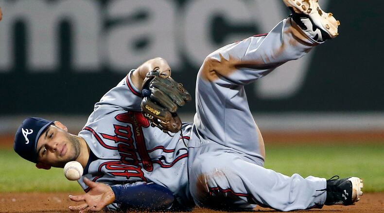 Atlanta Braves second baseman Tommy La Stella bobbles an infield hit by Boston Red Sox's Dustin Pedroia during the eighth inning of a baseball game at Fenway Park, Thursday, May 29, 2014, in Boston. (AP Photo/Winslow Townson)