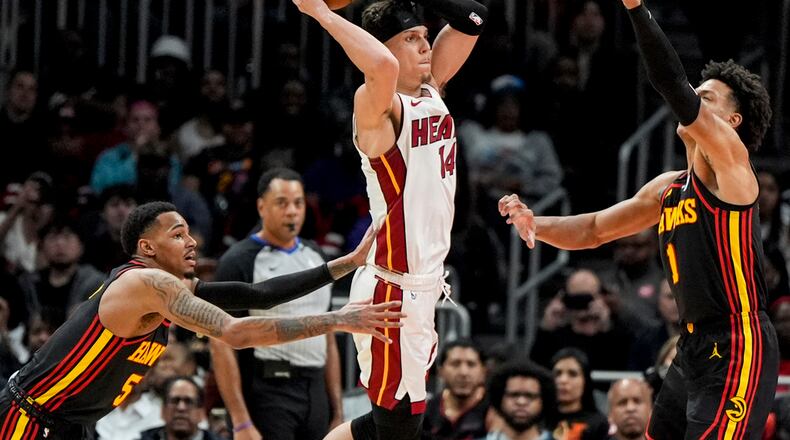 Miami Heat guard Tyler Herro (14) shoots against Atlanta Hawks forward Jalen Johnson (1) during the first half of an NBA basketball game, Tuesday, April 9, 2024, in Atlanta. (AP Photo/Mike Stewart)