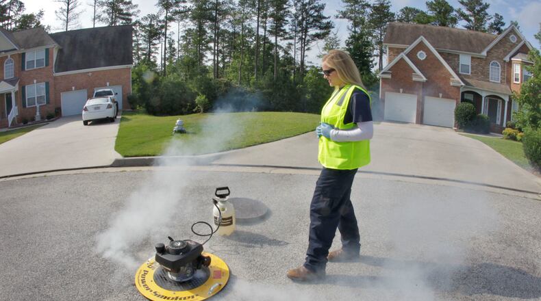 Andrea McLain, a sewer service mechanic, monitors a smoke test being run on a neighborhood line in Clayton County in 2012. DeKalb is conducting sewer line smoke testing over the next several months. BOB ANDRES / BANDRES@AJC.COM