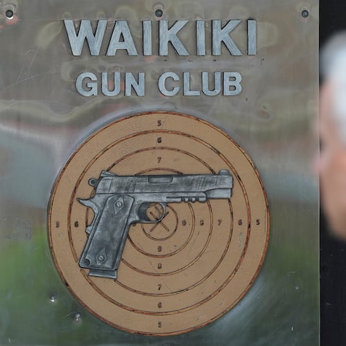 FILE - People walk past the Waikiki Gun Club, Thursday, June, 23, 2022 in Honolulu. (AP Photo/Marco Garcia)