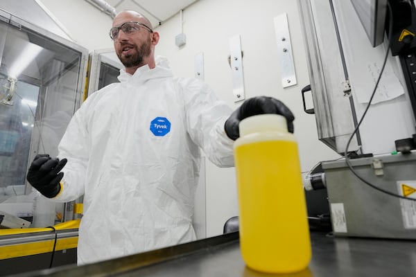 Dan Brown, vice president of fuel development for X-energy's subsidiary TRISO-X, demonstrates how liquid uranium is used to create TRISO fuel, Friday, June 27, 2025, in Oak Ridge, Tenn. (AP Photo/George Walker IV)