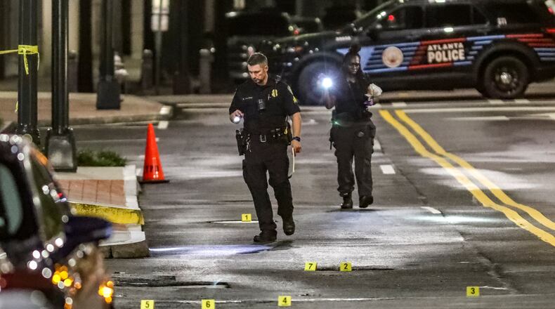 Police investigate a shooting scene on Spring Street in Midtown after 33-year-old security guard Sha'Darrian Jacobs was fatally wounded by a stray bullet Aug. 28. Three months later, 18-year-old Marion'Taye Holloman was arrested on charges related to the homicide.