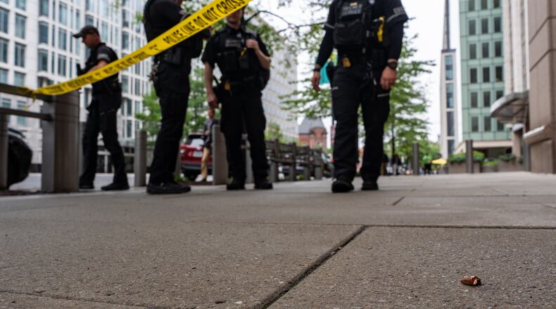 U.S. Secret Service Police officers place crime scene tape after a copper jacket of a bullet was found near the scene of a shooting close to the White House, Sunday, May 24, 2026, in Washington. (AP Photo/Alex Brandon)