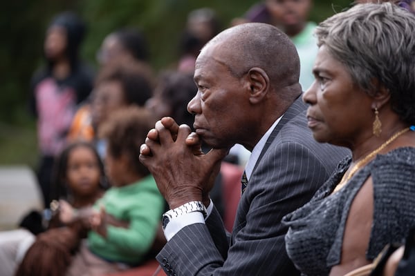 Divine Esomba listens to the message during a service in front of the burned-out Prayer City Eagles Chapel International Ministries in Austell on Sunday, Oct. 5, 2025. (Ben Gray for the AJC)