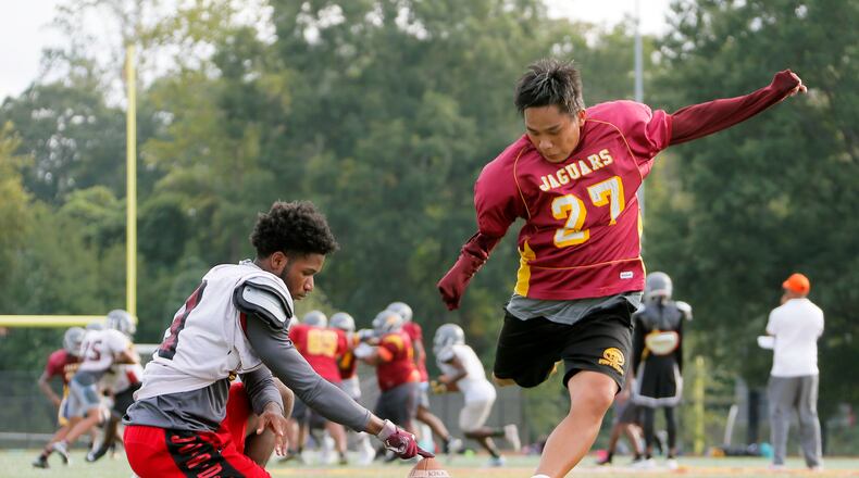 On the Maynard Jackson High School practice field, Jack Breedlove gets some kicks with his holder, Ayub Carswell. ( BOB ANDRES / BANDRES@AJC.COM)