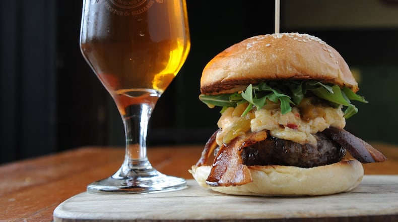 At Twain’s Brewpub & Billiards in Decatur, the Olivia Burger comes with pimento cheese, arugula, green tomato relish and bacon. It is served here with a pale ale. (Beckystein.com)