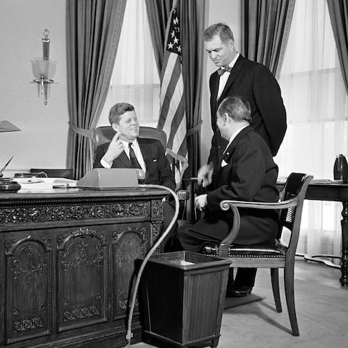 FILE - President John F. Kennedy gestures from behind a richly carved desk, made from the timbers of a British sailing ship, as he talks, Feb. 6, 1961 in his White House office in Washington with Mongi Slim, right, Tunisian Ambassador to the U.S., and G. Mennen Williams, Assistant Secretary of State for African Affairs. (AP Photo/HB, File)