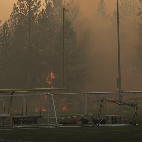 Old Trails Fire burns near Dwight Merkel Sports Complex, Saturday, Aug. 1, 2026, in Spokane, Wash. (AP Photo/Young Kwak)