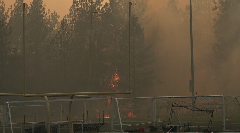 Old Trails Fire burns near Dwight Merkel Sports Complex, Saturday, Aug. 1, 2026, in Spokane, Wash. (AP Photo/Young Kwak)