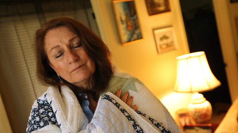 May 4, 2017, Peachtree City: Cancer survivor Roselynn Pearson wraps herself in the comfort and security of a quilt given to her by a fellow guest during her 8-months of treatment at the Atlanta Hope Lodge at her home on Thursday, May 4, 2017, in Peachtree City. Pearson had dropped her insurance coverage, because her pre-existing condition, a congenital heart defect, got excluded from insurance plans so it wasn’t covered; and in addition to that the premiums and deductibles were skyrocketing anyway. But then she got cancer. She counts herself lucky that Obamacare had just come online and she was able to sign up for coverage for her cancer treatment. Curtis Compton/ccompton@ajc.com