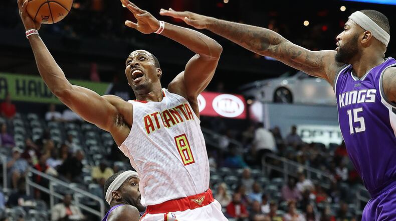 Hawks’ Dwight Howard is fouled on his way to the basket on a double team by Kings’ Ty Lawson and DeMarcus Cousins during the second period in an NBA basketball game on Monday, Oct. 31, 2016, in Atlanta. Curtis Compton /ccompton@ajc.com
