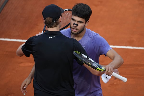 Carlos Alcaraz of Spain, back, embraces Jannik Sinner of Italy during their final tennis match in the Italian Open at the Foro Italico in Rome, Sunday, May 18, 2025. (AP Photo/Andrew Medichini)