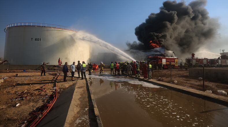 Firefighters work to contain a fire at the Zawiya oil refinery following a drone strike in Zawiya, Libya, Tuesday, Aug. 11, 2026. (AP Photo/Yousef Murad)