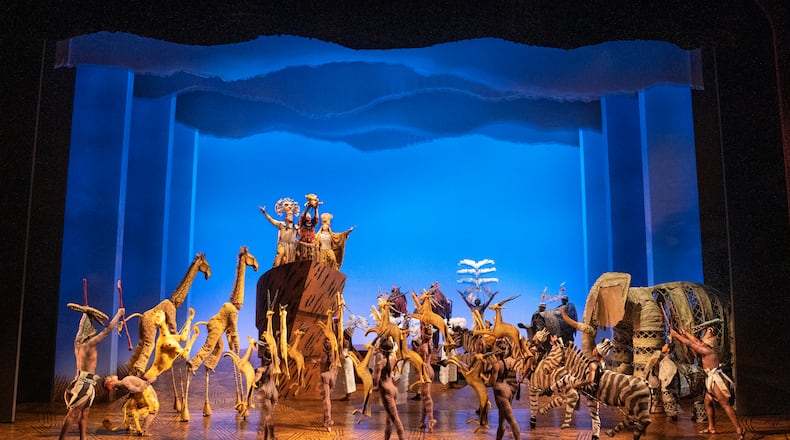 At the climax of “Circle of Life,” the opening of “The Lion King,” the cast is gathered onstage. That includes former Atlantan Courtney Thomas, walking on stilts to play one of the 14-foot-tall giraffes. (Photo by Matthew Murphy)