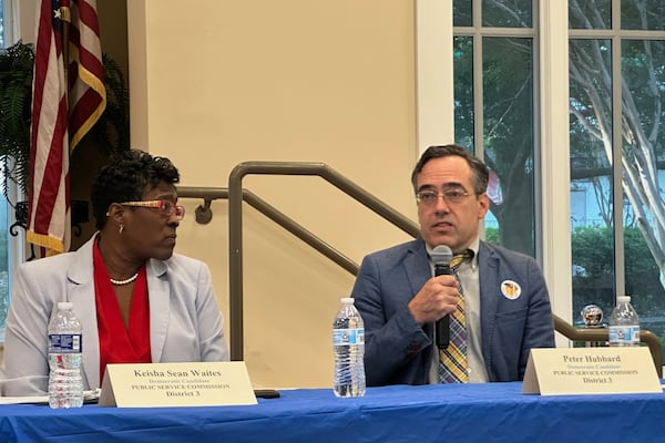 Keisha Sean Waites, left, looks on as Peter Hubbard speaks at a Democratic candidate forum for the Georgia Public Service Commission runoff in Fayetteville, Ga., on Thursday, July 10, 2025. (AP Photo/Jeff Amy)