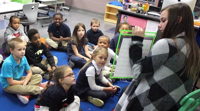 A teacher instructs first graders in addition and subtraction.