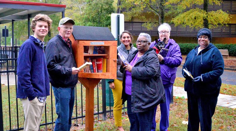 Residents and staff gather around one of four Little Free Libraries installed in 2019 by a Boy Scout (at left) on the campus of the Christian City senior facility in Union City.