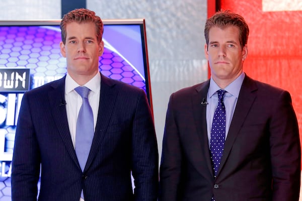 FILE - Cameron Winklevoss, left, and Tyler Winklevoss, founders of Gemini Trust Co., wait to appear on the "Countdown to the Closing Bell with Liz Claman" program, on the Fox Business Network, in New York, Oct. 8, 2015. (AP Photo/Richard Drew, File)