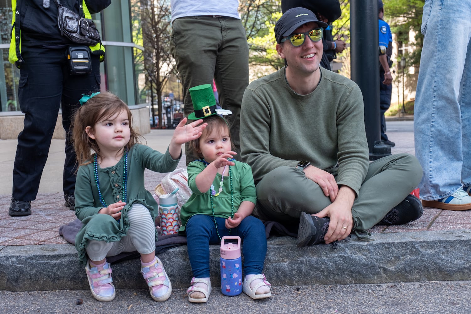 Naomi, Jane and Caleb Kirksey watch the Atlanta St. Patrick’s Parade pass by on Saturday, March 14, 2026. (Ben Gray for the AJC)