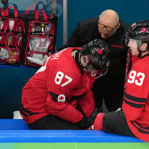 Canada's Sidney Crosby (87) is attended to after being injured during the second period of a men's ice hockey quarterfinal game between Canada and Czechia at the 2026 Winter Olympics, in Milan, Italy, Wednesday, Feb. 18, 2026. (AP Photo/Hassan Ammar)