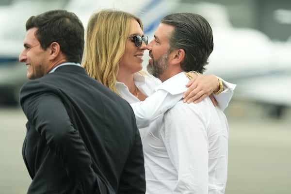 Donald Trump Jr., from right, and Bettina Anderson wait for the arrival of President Donald Trump at Teterboro Airport in Teterboro, N.J., en route to attend the Club World Cup final soccer match, Sunday, July 13, 2025. (AP Photo/Jacquelyn Martin)