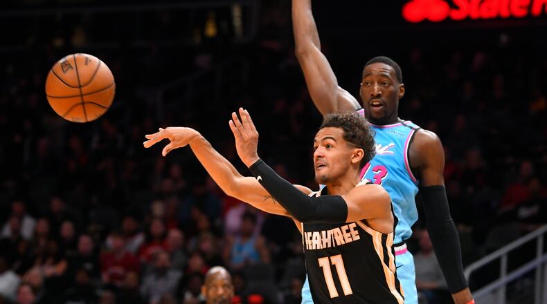 Hawks guard Trae Young passes as Heat forward Bam Adebayo defends Thursday's Atlanta-Miami game at State Farm Arena. (AP photo/John Amis)