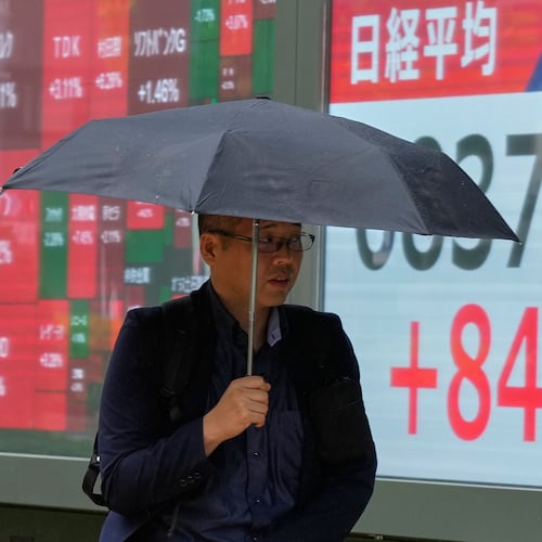 A person walks in front of an electronic stock chart board showing Japan's Nikkei index at a securities firm Thursday, Aug. 13, 2026, in Tokyo. (AP Photo/Eugene Hoshiko)