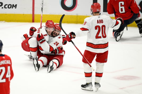 Carolina Hurricanes center Seth Jarvis (24) celebrates his empty net goal with right wing Andrei Svechnikov (37) and center Sebastian Aho (20) in the third period of Game 5 of a second-round NHL hockey playoff series against the Washington Capitals Thursday, May 15, 2025, in Washington. (AP Photo/Nick Wass)