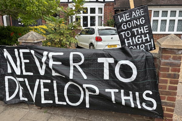 A banner opposed to Wimbledon's major expansion plan is placed outside a house leading to the All England Club where the Wimbledon Tennis Championships take place in London, Saturday, July 5, 2025. (AP Photo/Tony Hicks)