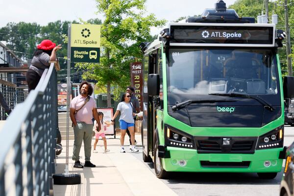 A person interacts with an ATL Spoke staffer as the ATL Spoke autonomous bus is seen at West + Lee District on Monday, June 1, 2026. The ATL Spoke pilot program’s initial route links the Beltline Southwest Trail to MARTA Rail. It includes stops at MARTA West End Station, Joseph E. Lowery Blvd at Beecher Street, and two stops within the Lee + White district.  (Miguel Martinez/AJC)