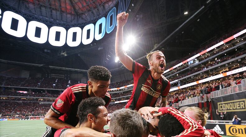 Nov 11, 2018 Atlanta: Atlanta United midfielder Miguel Almiron is covered up by teammates after scoring his teamâs second goal of the night on a penalty kick for a 2-0 lead over New York City during the first half in their MLS Eastern Conference Semifinal playoff match on Sunday, Nov. 11, 2018, in Atlanta.  Curtis Compton/ccompton@ajc.com