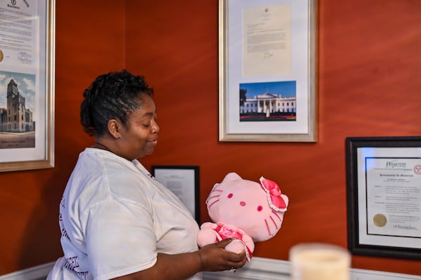 Francine Moffett holds a Hello Kitty plushie, which was her daughter Sgt. Breonna Moffett’s favorite character, in the dining room of their family home in Savannah. (Sarah Peacock for the AJC)