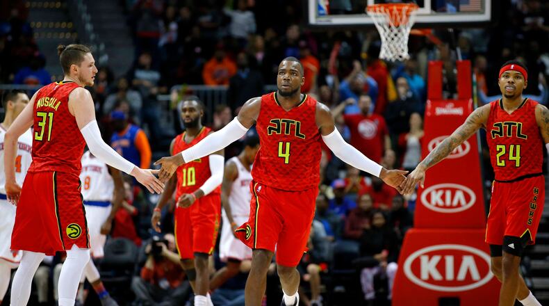Atlanta Hawks forward Paul Millsap (4) reacts with forward Mike Muscala (31) and forward Kent Bazemore (24) in the fourth overtime of an NBA basketball game against the New York Knicks on Sunday, Jan. 29, 2017, in Atlanta. The Hawks won the game in the fourth overtime 142-139. (AP Photo/Todd Kirkland)