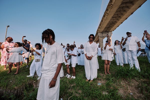 People watch as a wreath is thrown into the Mobile River as a part of memorial ceremony for African slaves transporter aboard the Clotilda on Saturday, July 5, 2025 in Mobile, Ala. (Dan Anderson/AP)