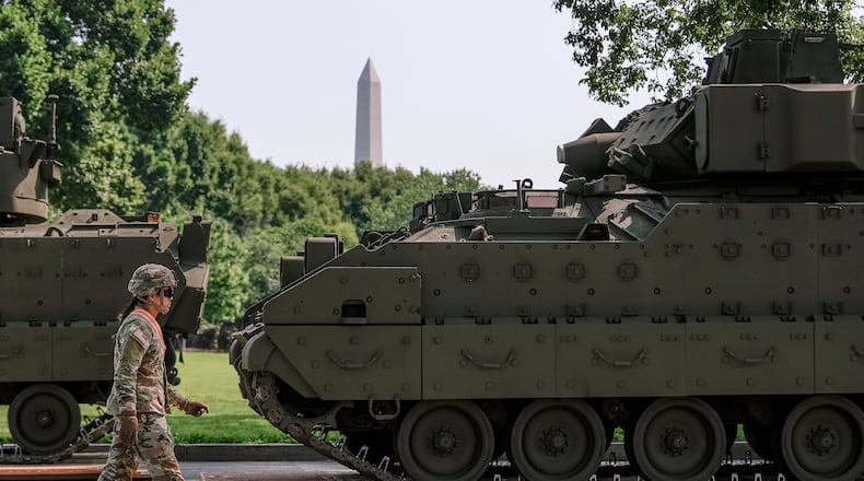 FILE - A U.S. Army soldier walks past a Bradley fighting vehicle staged in West Potomac Park ahead of an upcoming military parade commemorating the Army's 250th anniversary and coinciding with Donald Trump's 79th birthday, June 11, 2025, in Washington. (AP Photo/Julia Demaree Nikhinson, File)