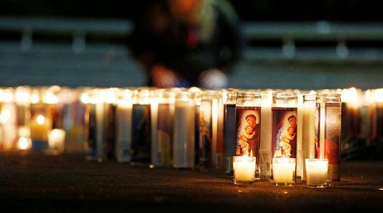 Candles spell out the initials for Umpqua Community College at a candlelight vigil Thursday, Oct. 1, 2015, in Roseburg, Ore. According to police a man opened fire at Umpqua Community College Thursday before dying in a shootout with police. (AP Photo/John Locher)
