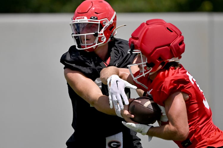 Georgia quarterback Ryan Puglisi (12) makes a handoff to Georgia running back Cash Jones (32) during football practice at the University of Georgia practice facility, Thursday, July 31, 2025, in Athens. (Hyosub Shin / AJC)