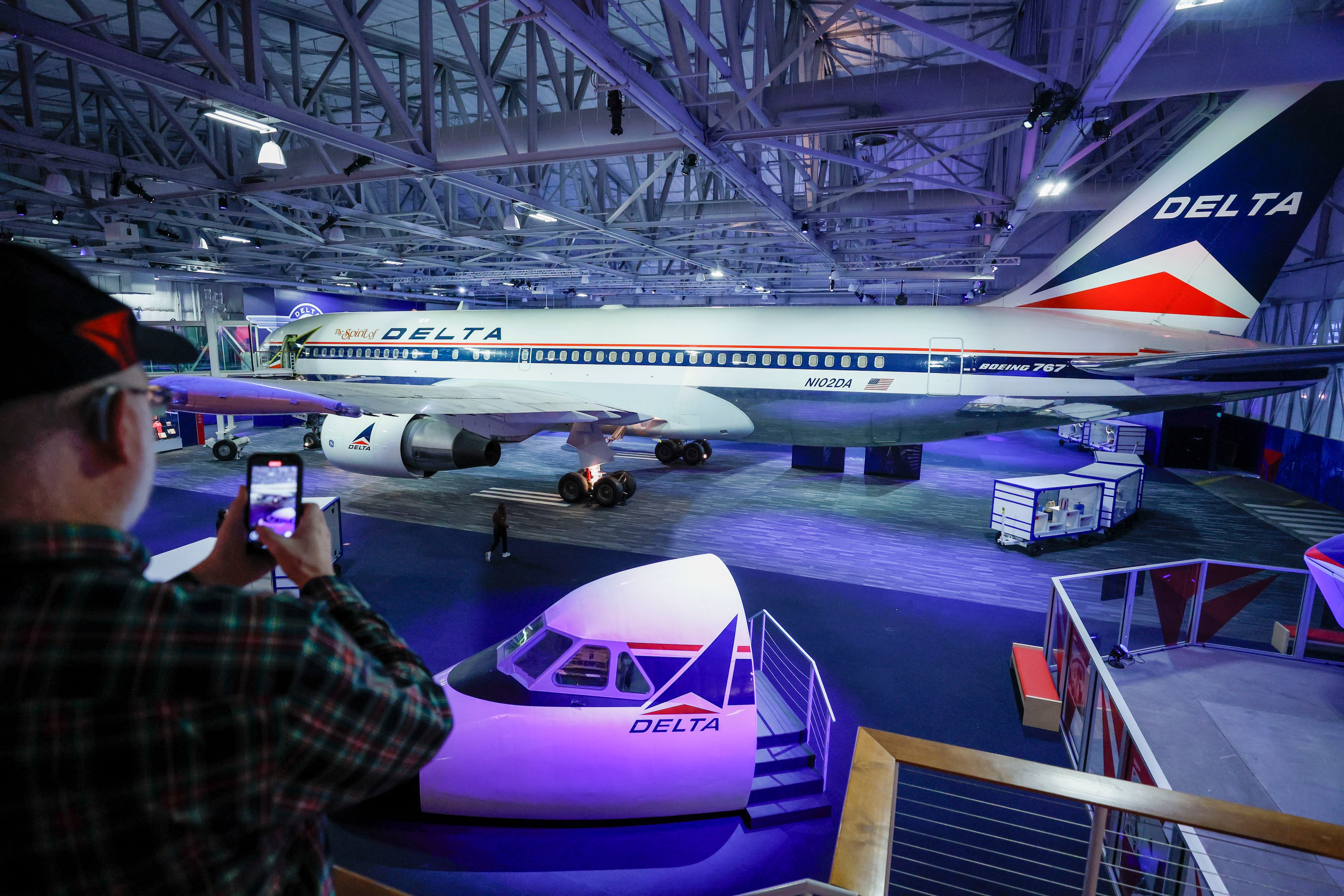 A man records a video of the Spirit of Delta, a Boeing 767 airplane on display at the Spirit Hangar, during a media tour of the remodeled Delta Flight Museum at Hartsfield-Jackson Atlanta International Airport. Delta has been criticized for using AI in its fare pricing. (Miguel Martinez/AJC)