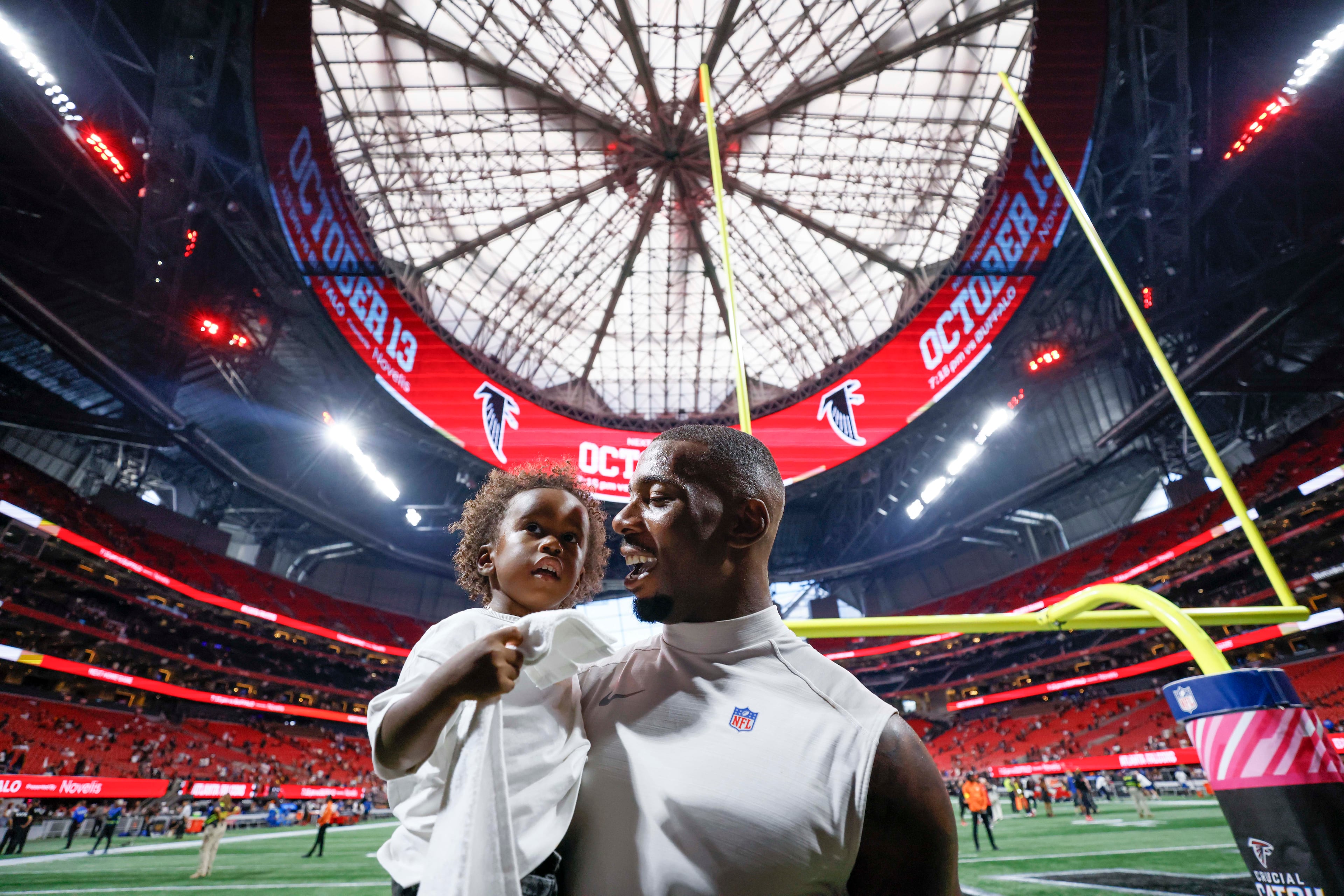 Atlanta Falcons tight end Kyle Pitts holds his son Kyle Anthony Pitts Jr. after the Falcons beat the Washington Commanders 34-27 at Mercedes-Benz Stadium in Atlanta on Sunday, September 28, 2025. (Miguel Martinez/AJC)