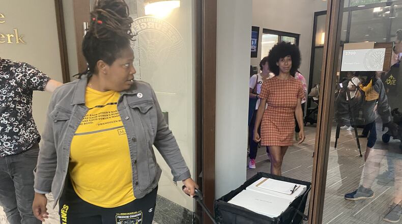 Organizers Mary Hooks, left, and Mariah Parker, right, walk out of the municipal clerk's office at Atlanta city hall with 3,000 copies of the petition referendum forms. The group will have 60 days to collect more than 70,000 signatures from registered Atlanta voters.